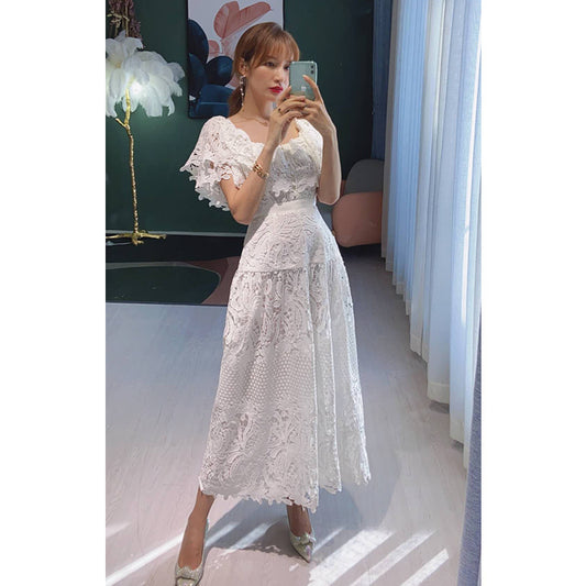 Robe longue blanche brodée de fleurs, petit encens sur les épaules